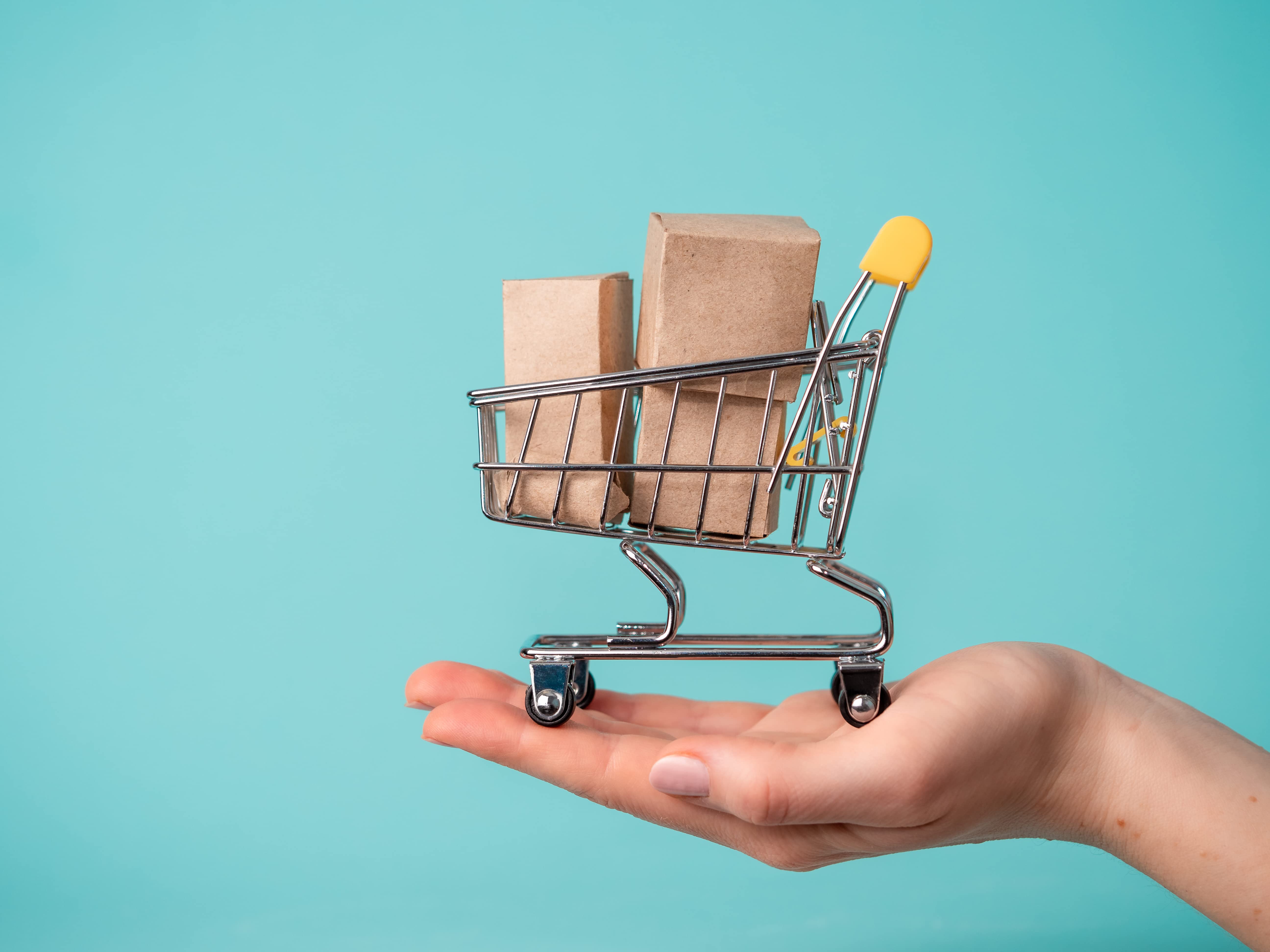 image of a hand holding a miniature shopping cart with boxes inside the cart, used to represent the benefits of a product trend