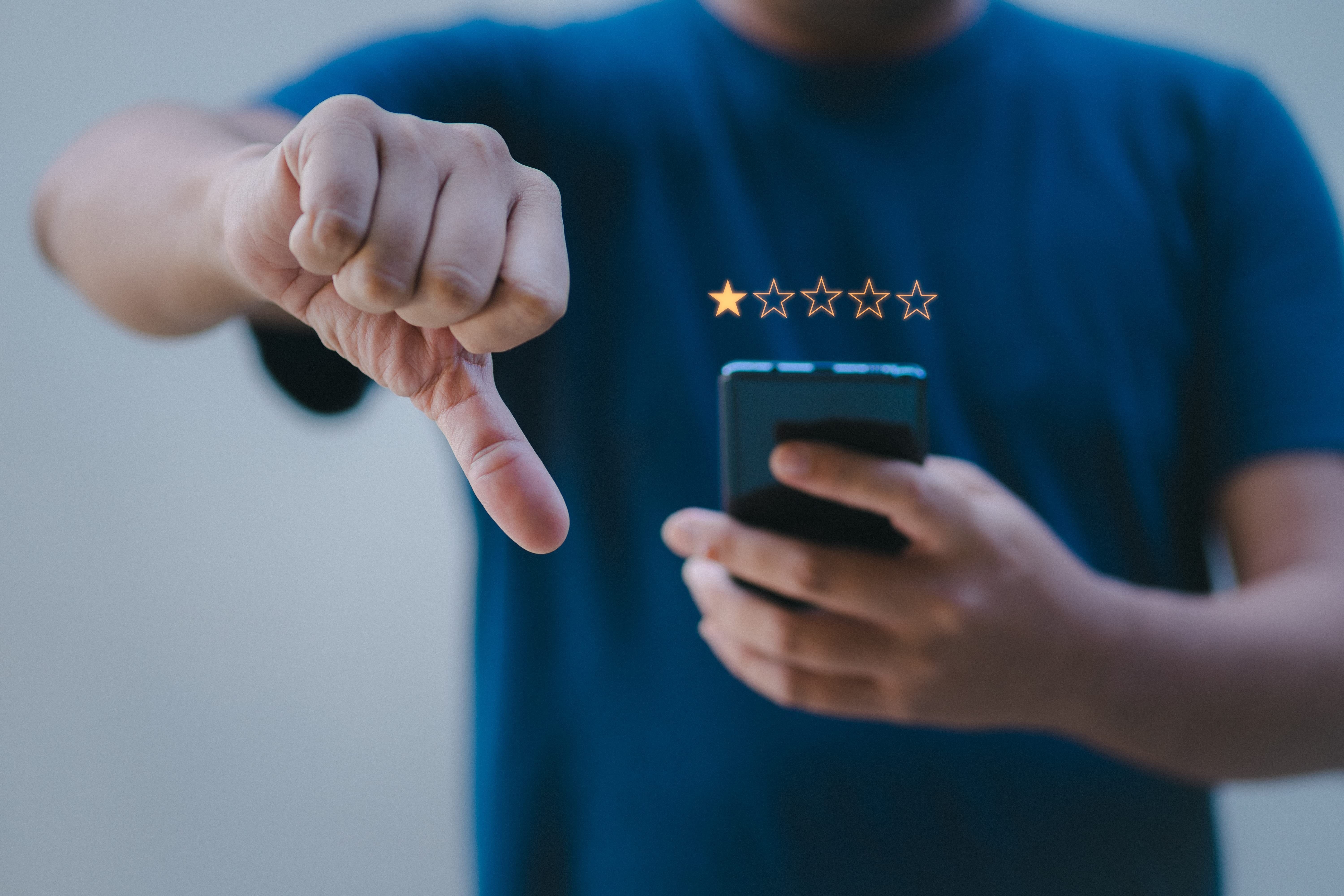Image shows a man with a negatively connotative thumbs down and one star next his thumb- the effects of negative customer experience. 